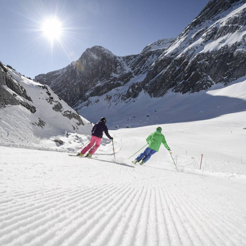 Skifahrer bei Abfahrt im Schnee