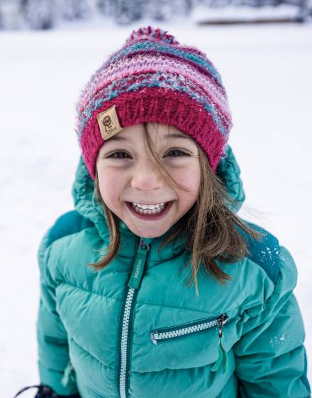 Kind im Winter grinst in die Kamera