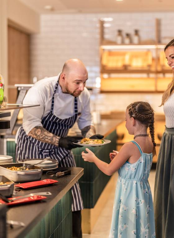 Koch gibt Teller an Kind