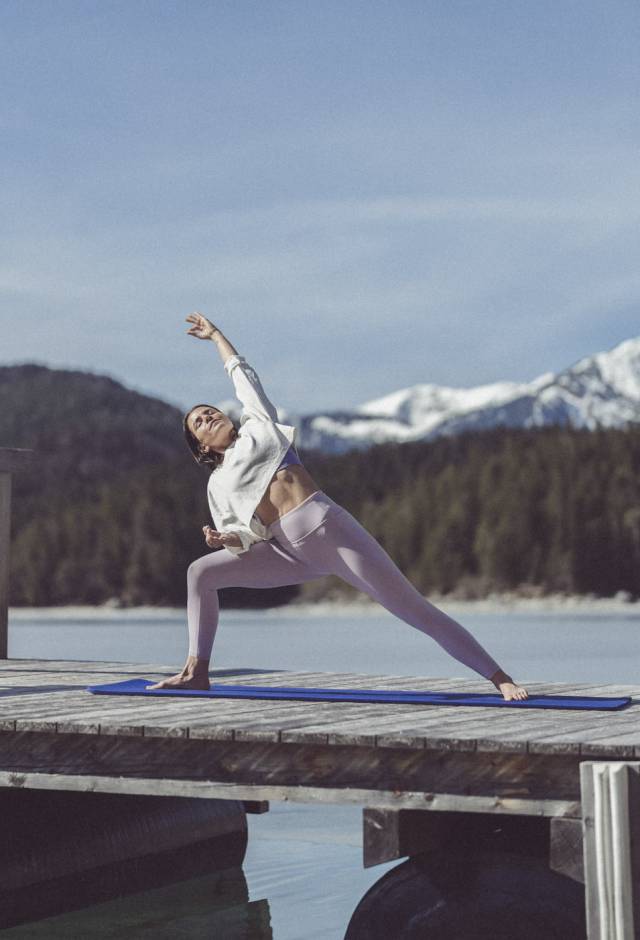 Frau macht Yoga auf dem Steg zum Eibsee
