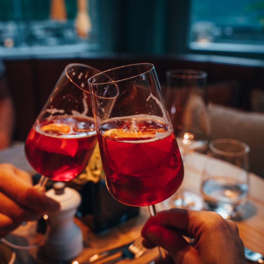 Männer stoßen mit Aperitif an