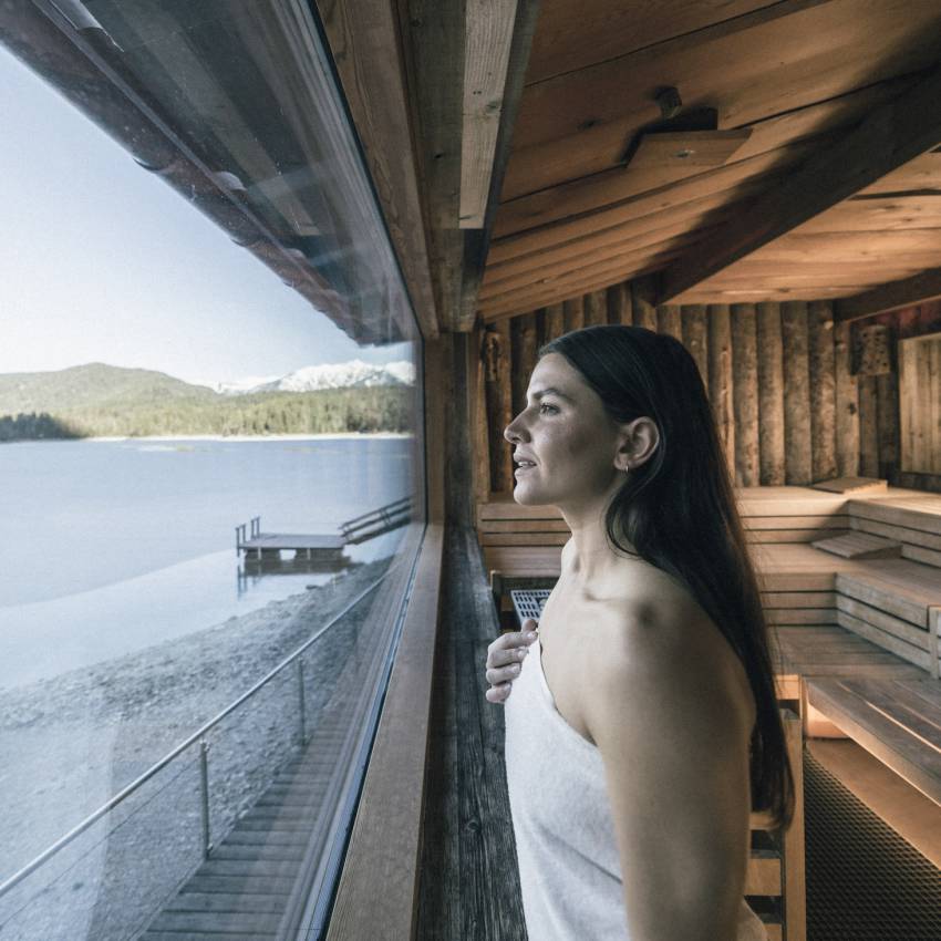 Frau blickt aus der Sauna auf den Eibsee