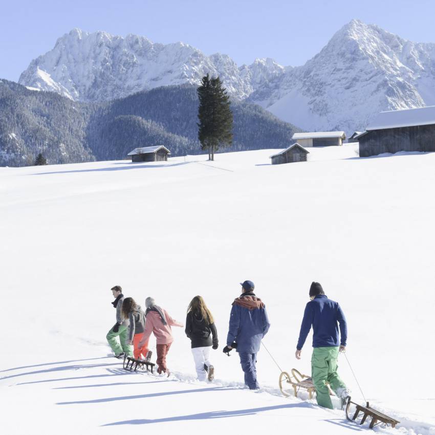Familie zieht Schlitten im Schnee
