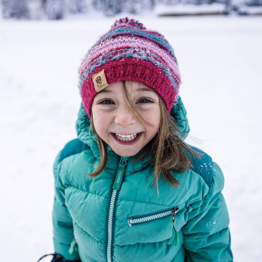 Kind im Winter grinst in die Kamera