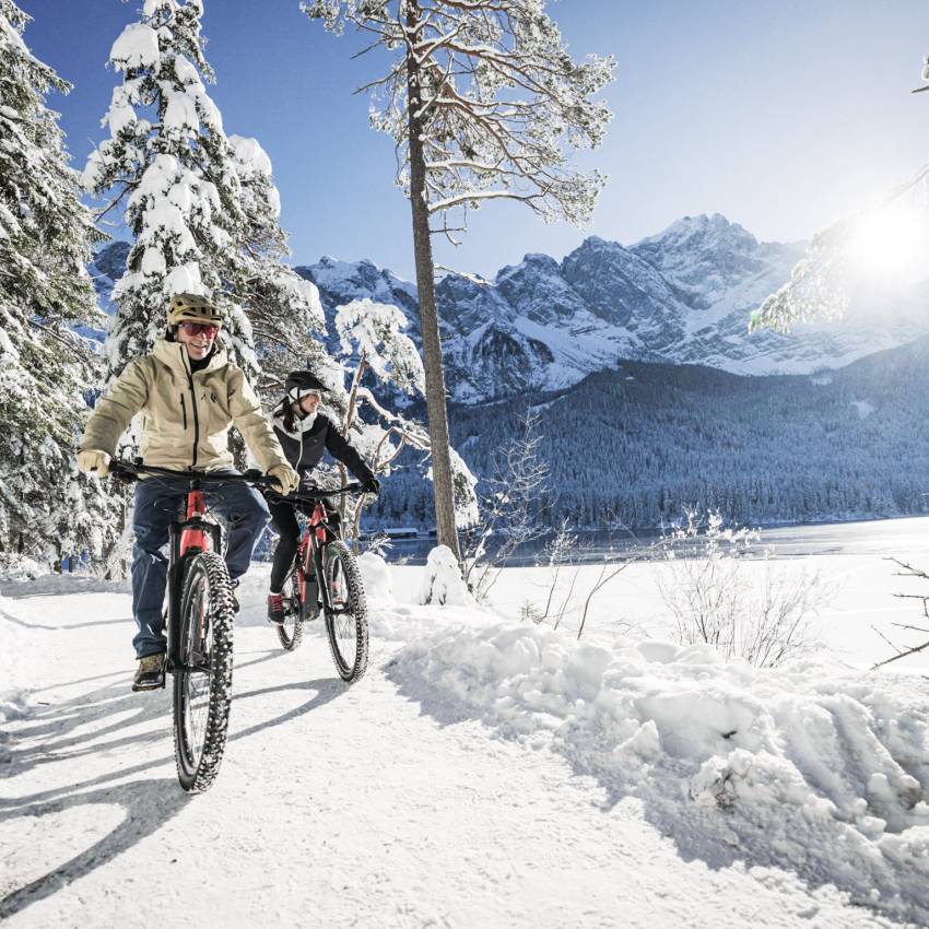 Man und Frau beim Winterbiken am Eibsee
