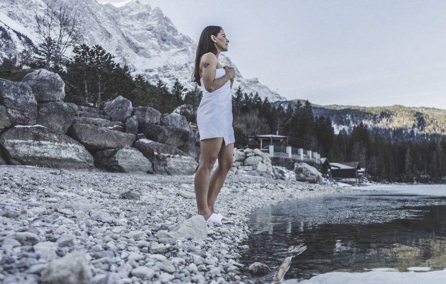 Frau im Winter im Handtuch blickt auf den Eibsee