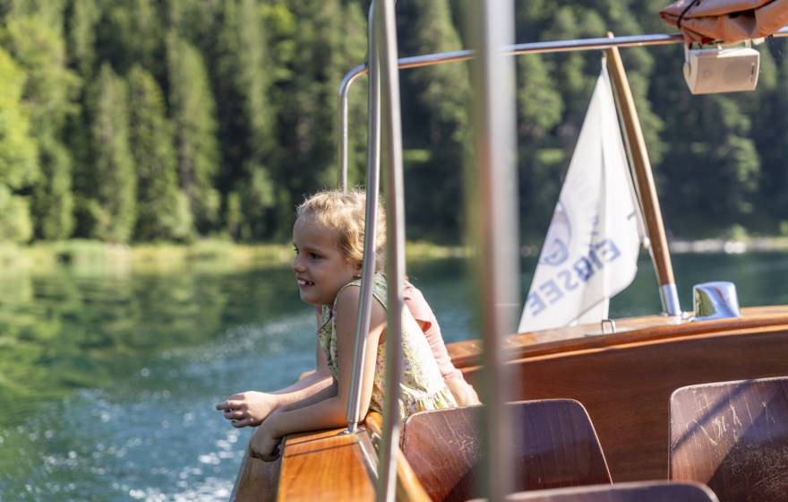 Kind sitzt im Boot auf dem Eibsee