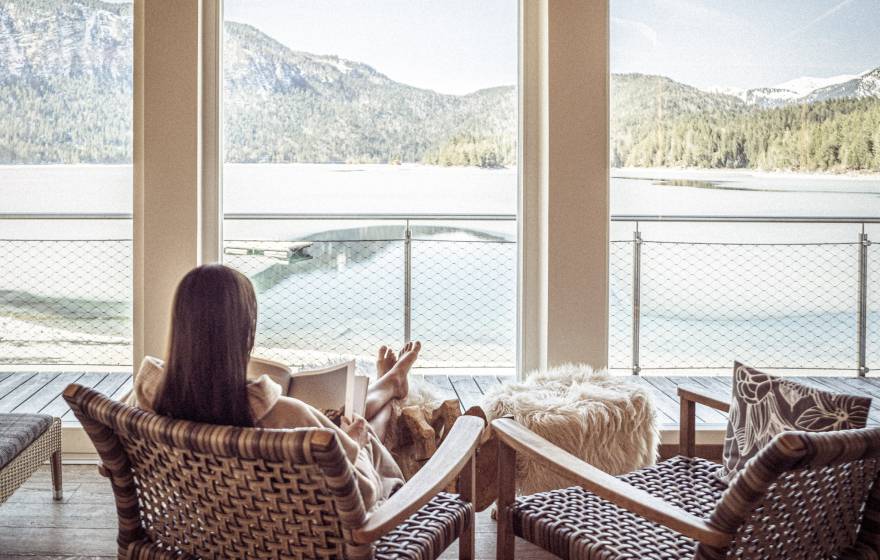 Frau entspannt im Ruheraum mit Blick auf den Eibsee
