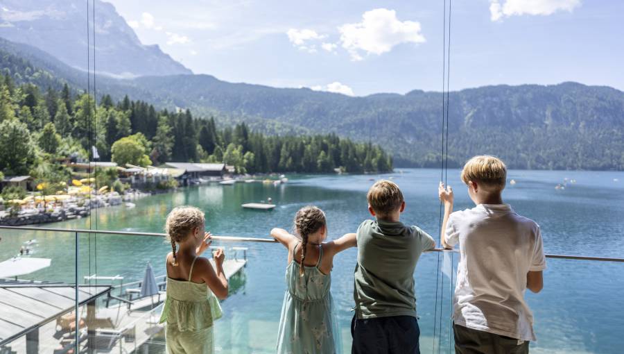 Kinder stehen an Geländer und blicken auf den Eibsee