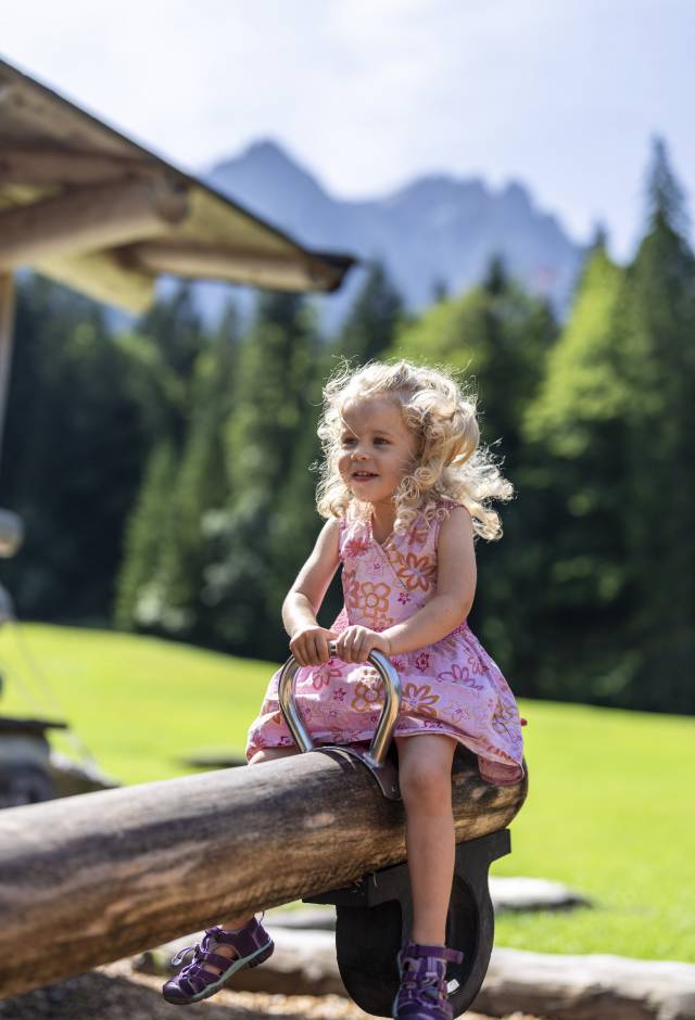 Kind auf einer Holzwippe