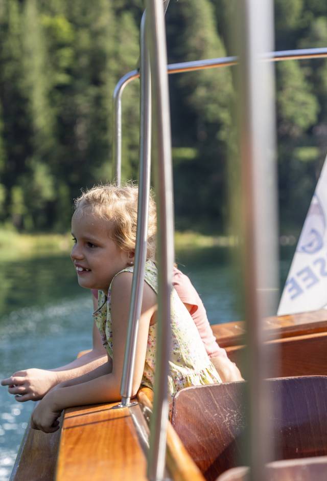 Kind sitzt im Boot auf dem Eibsee