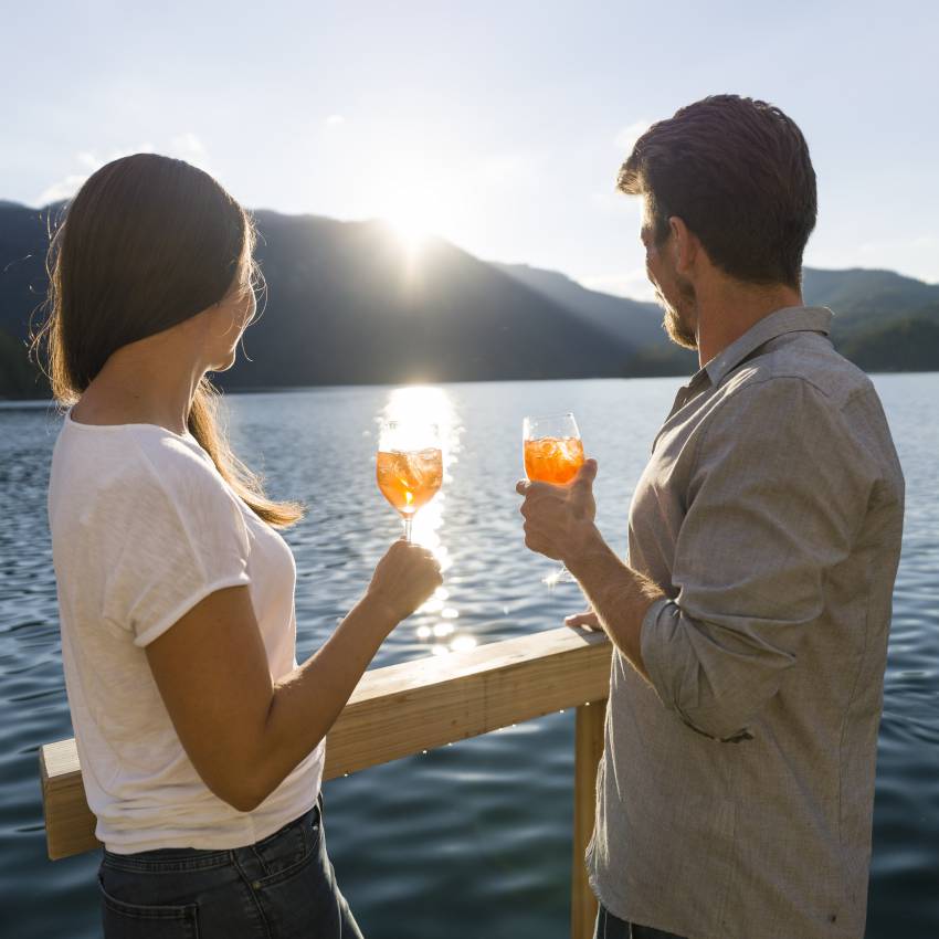 Paar genießt Aperol mit Blick auf den Eibsee in der Sonne