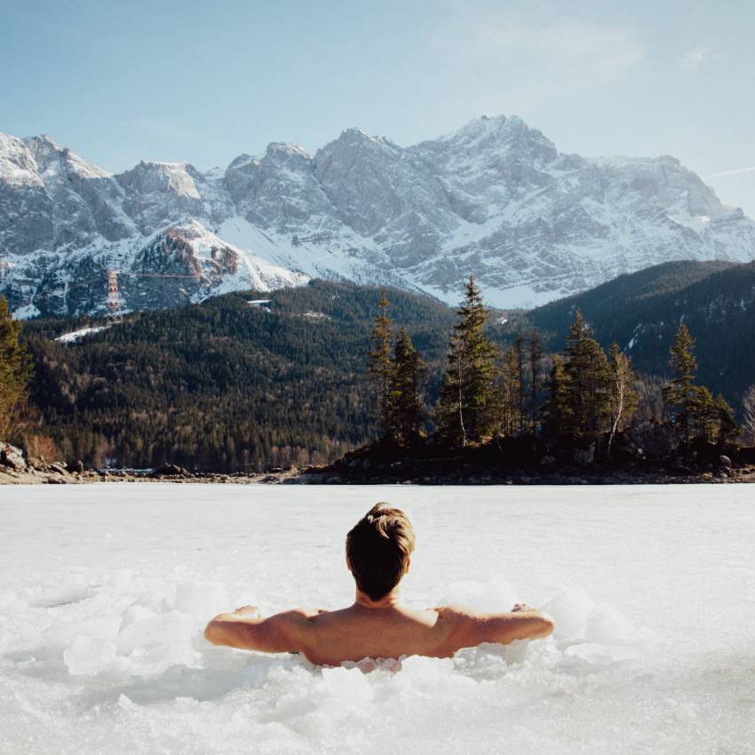 Mann badet im verschneiten Eibsee