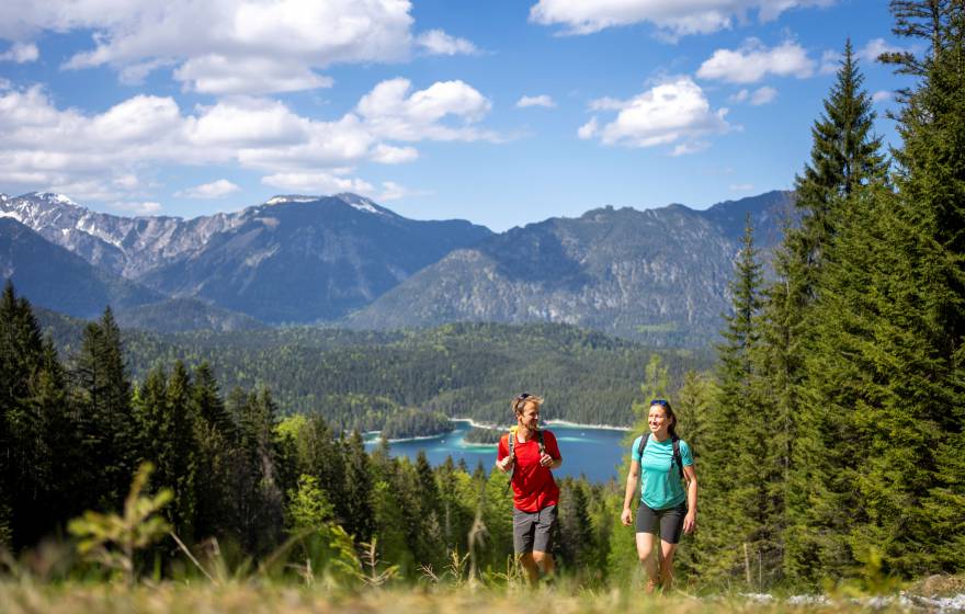 Mann und Frau beim Wandern Richtung Zuspitze mit dem Eibsee im Hintergrund