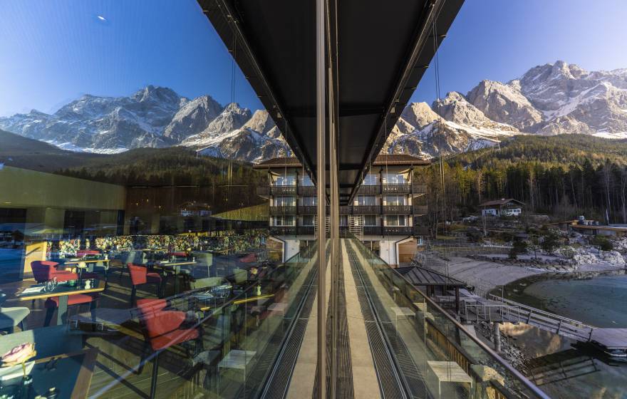 Zugspitze spiegelt sich in Fensterscheibe des Restaurants