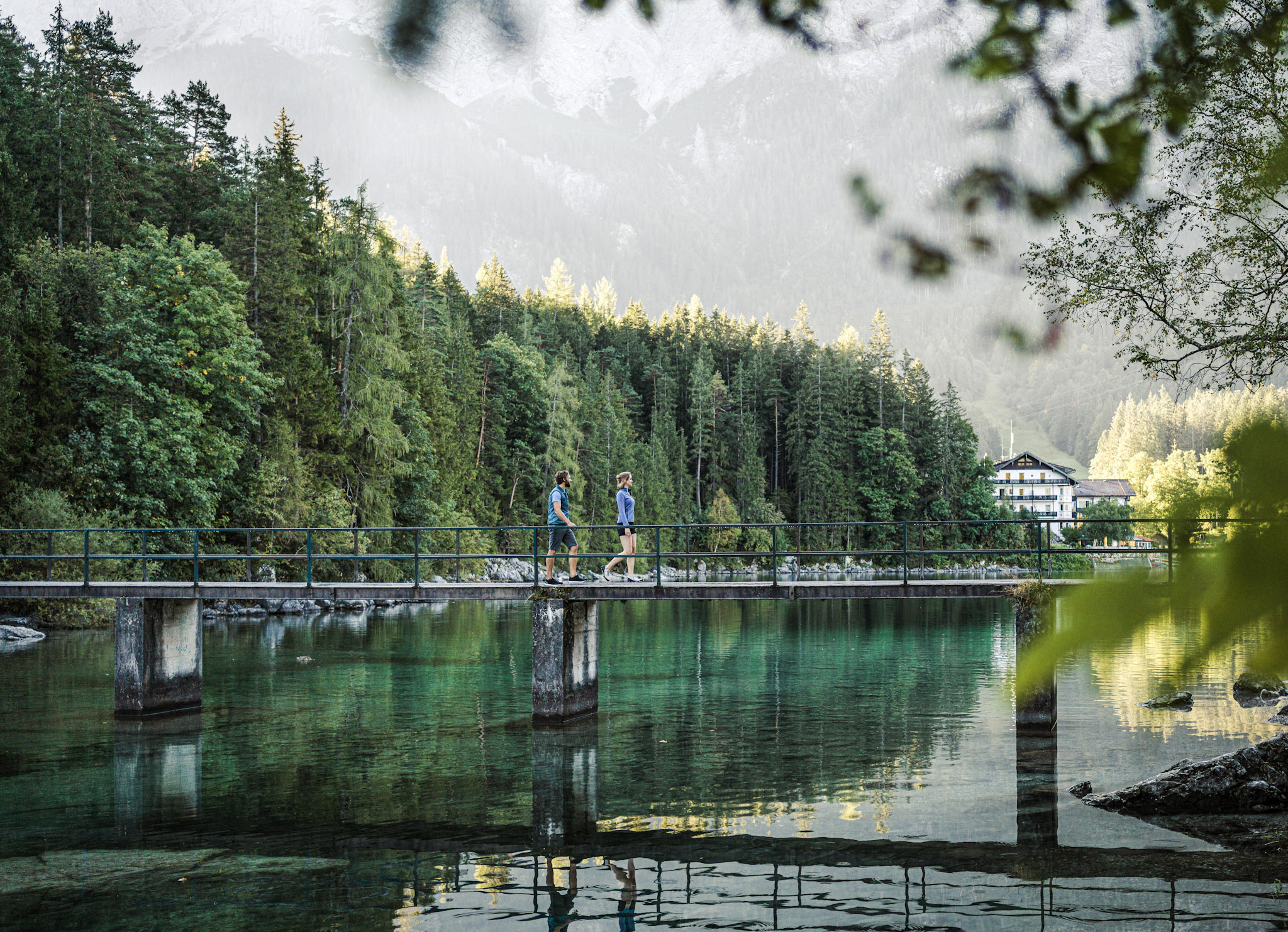 Mann und Frau laufen über Steg am Eibsee