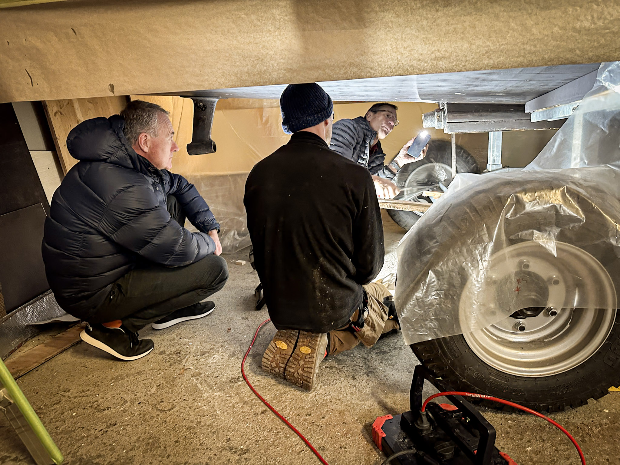 Männer begutachten Holzboot