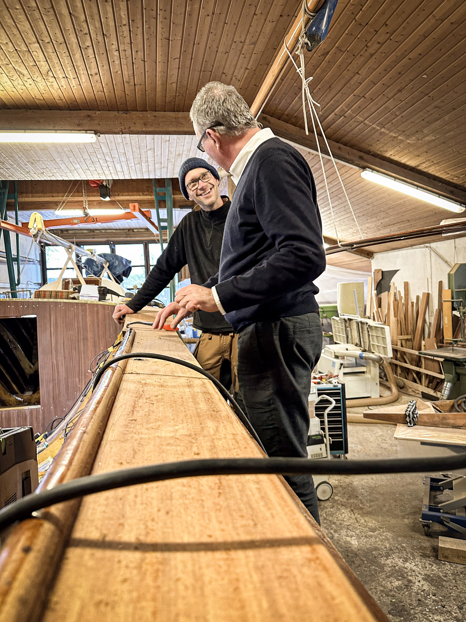 Männer stehen vor Boot und unterhalten sich